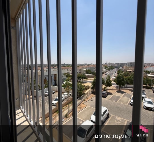 נוף עירוני מבעד לסורגים בחלון